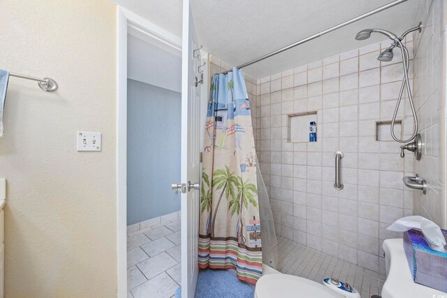 bathroom with tile patterned flooring, toilet, and curtained shower