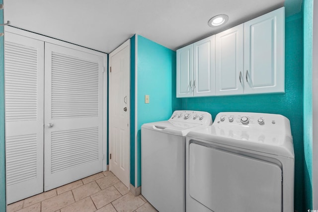 washroom with washer and clothes dryer, cabinets, and light tile patterned floors