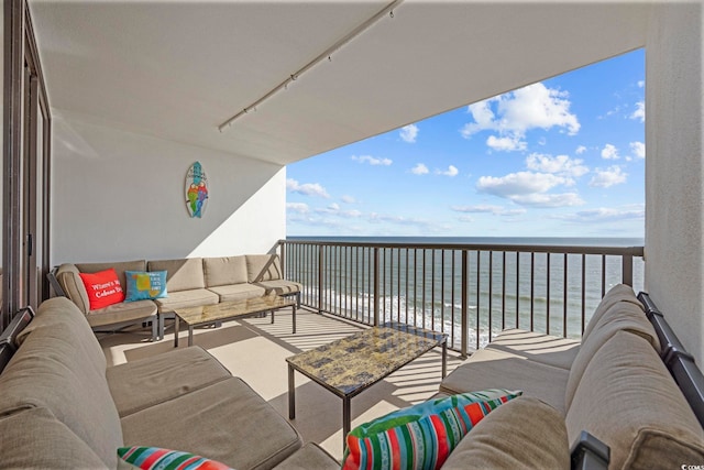 balcony with a water view and an outdoor hangout area