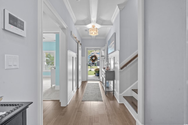 foyer entrance featuring hardwood / wood-style floors, a barn door, beam ceiling, and crown molding