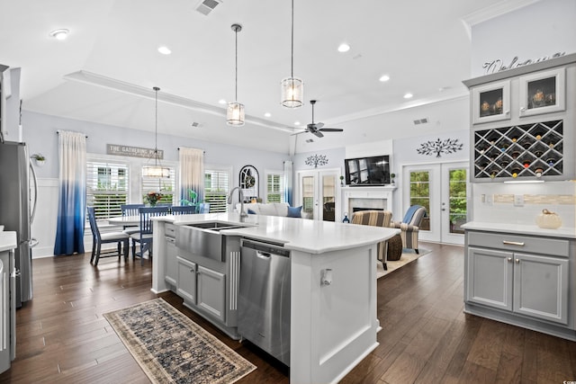 kitchen with a wealth of natural light, appliances with stainless steel finishes, sink, and gray cabinetry