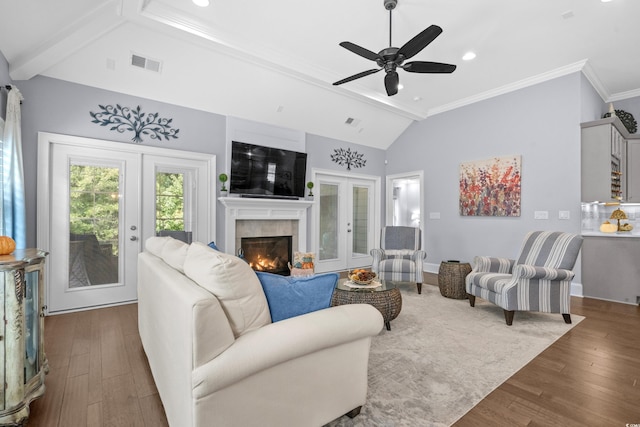 living room with ceiling fan, french doors, a tiled fireplace, and dark hardwood / wood-style flooring