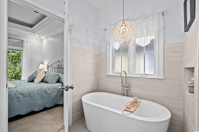 bathroom featuring tile walls, a bathing tub, ornamental molding, and a chandelier