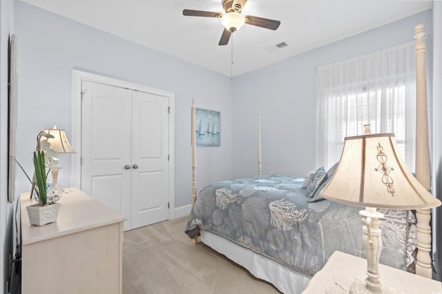 bedroom featuring a closet, light carpet, and ceiling fan