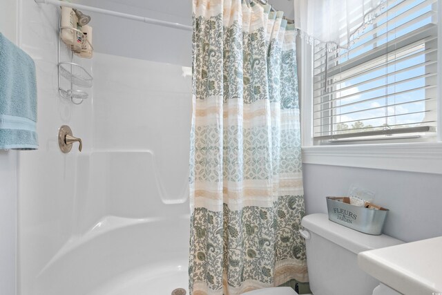 bathroom featuring a shower with shower curtain and toilet