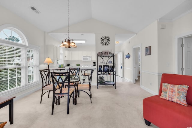 carpeted dining room featuring lofted ceiling and an inviting chandelier