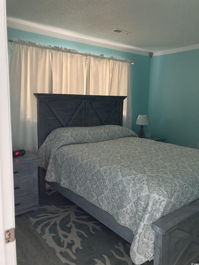 bedroom featuring crown molding and a textured ceiling