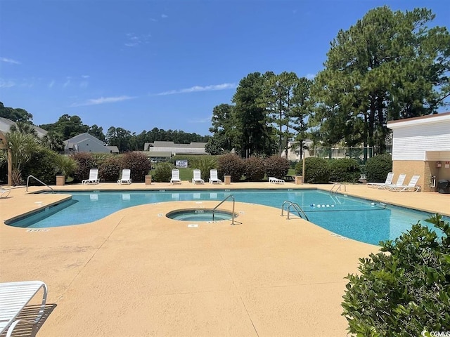 view of swimming pool with a patio area and a community hot tub