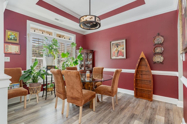 dining area featuring light hardwood / wood-style flooring and ornamental molding