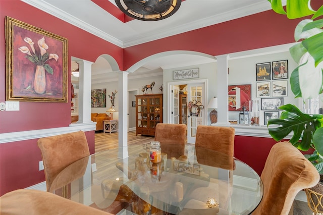 dining space featuring ornate columns, french doors, light hardwood / wood-style flooring, and crown molding