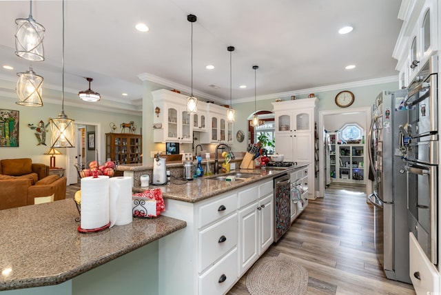 kitchen with decorative light fixtures, hardwood / wood-style flooring, crown molding, and white cabinets