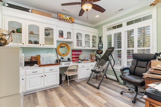 office space with ceiling fan, built in desk, crown molding, and light hardwood / wood-style flooring