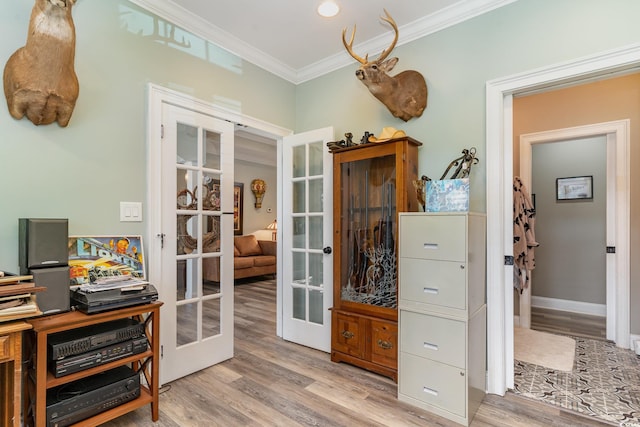 home office with light wood-type flooring, french doors, and ornamental molding