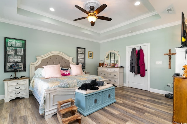 bedroom featuring ceiling fan, a raised ceiling, and dark hardwood / wood-style flooring