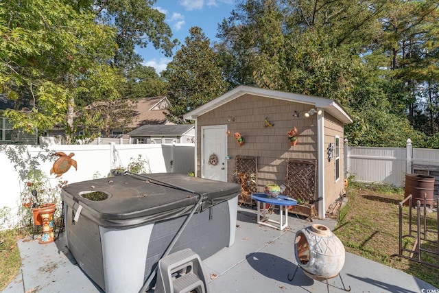 view of patio / terrace featuring area for grilling, a storage shed, and a hot tub