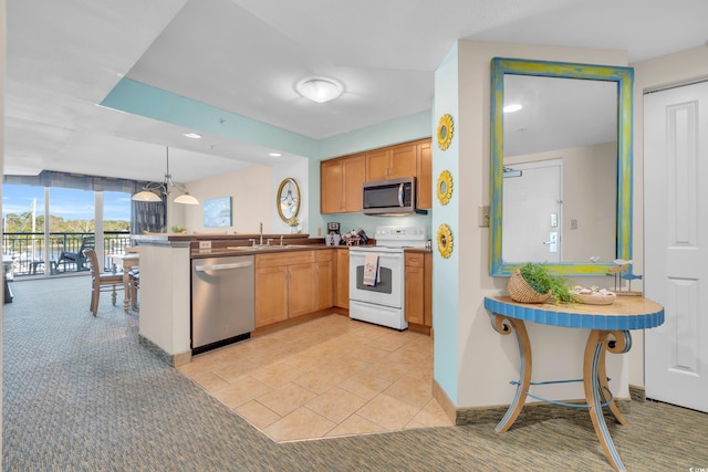 kitchen with sink, kitchen peninsula, decorative light fixtures, and stainless steel appliances