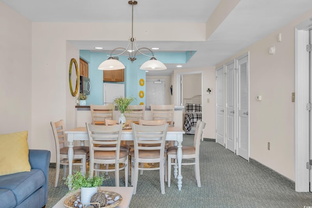 dining area with a chandelier and carpet