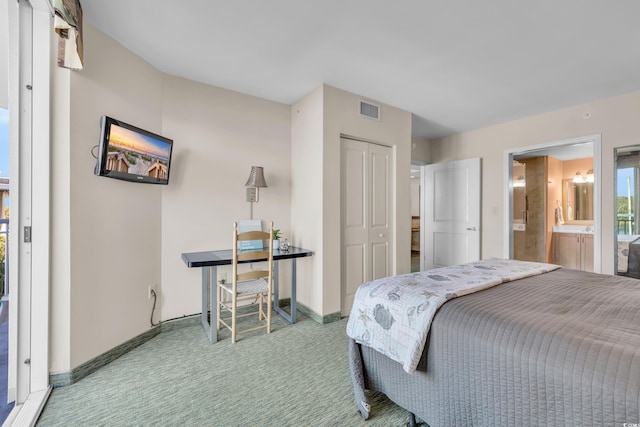 bedroom with a closet, ensuite bath, and carpet floors