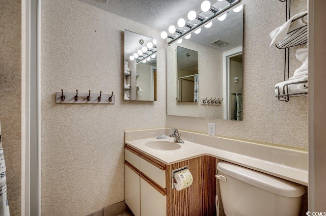 2609 S Ocean Blvd Unit 403, North Myrtle Beach, SC 29582 - bathroom featuring toilet, vanity, and a textured wall