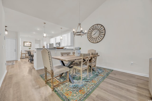 dining room with light hardwood / wood-style floors and an inviting chandelier