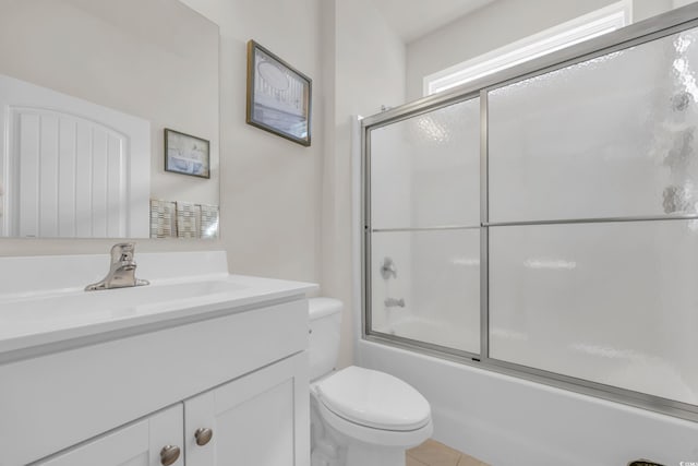 full bathroom with shower / bath combination with glass door, tile patterned floors, vanity, and toilet