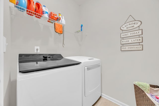 laundry area featuring washer and clothes dryer and light tile patterned flooring