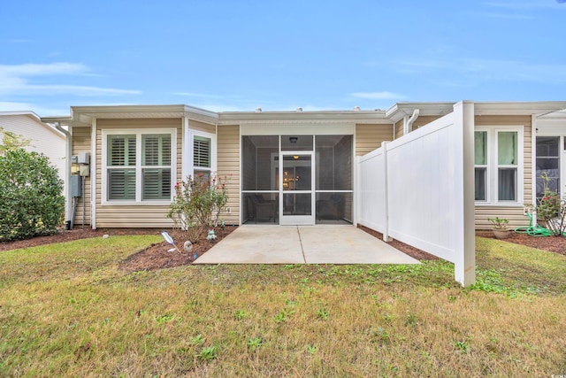 rear view of property with a patio area, a sunroom, and a yard