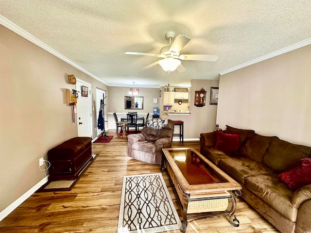 living room with a textured ceiling, light hardwood / wood-style flooring, ceiling fan, and crown molding