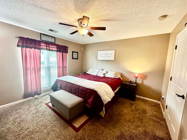 bedroom featuring a textured ceiling, dark carpet, and ceiling fan