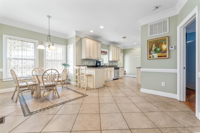 kitchen with cream cabinets, ornamental molding, light tile patterned floors, pendant lighting, and stainless steel dishwasher