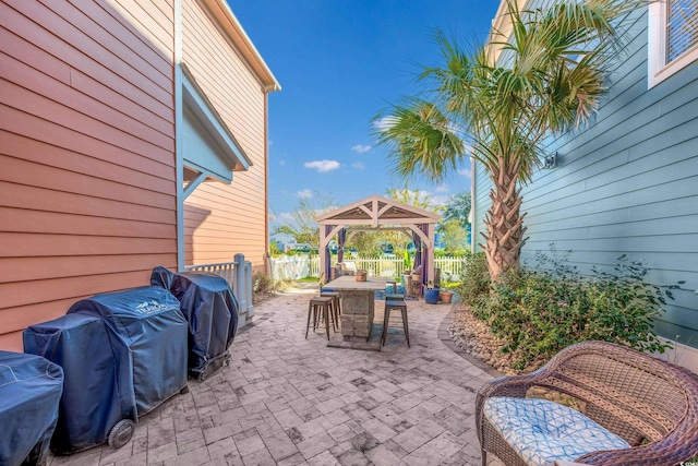 view of patio / terrace featuring a gazebo, a fenced backyard, outdoor dining area, and a grill