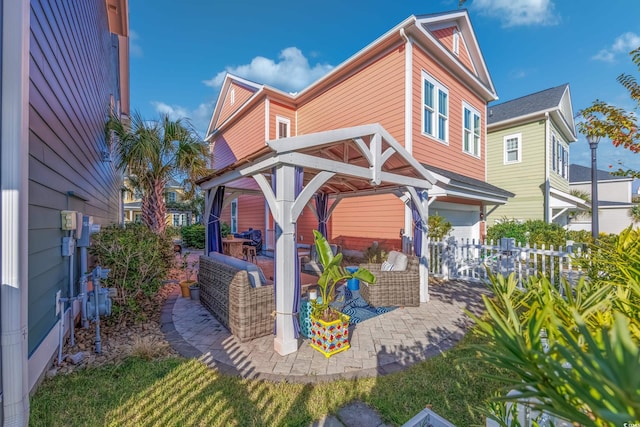 view of side of property featuring fence, an attached garage, a patio area, and outdoor lounge area
