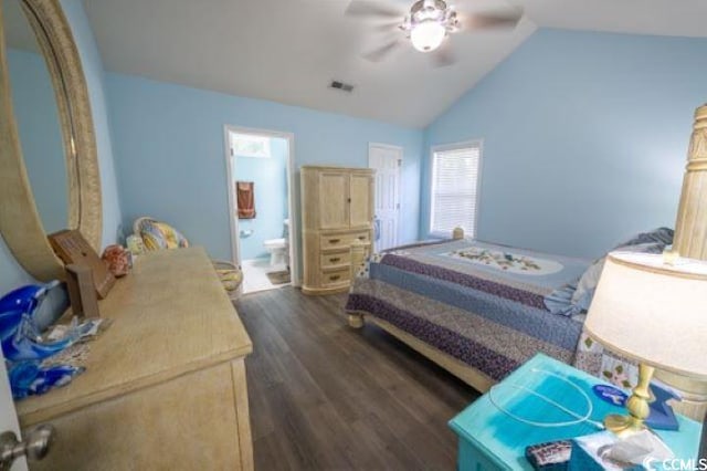 bedroom with dark wood-type flooring, ceiling fan, ensuite bath, and vaulted ceiling