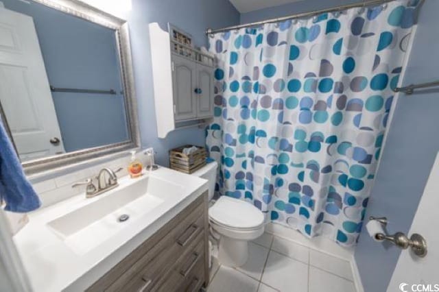 bathroom featuring toilet, vanity, a shower with shower curtain, and tile patterned flooring