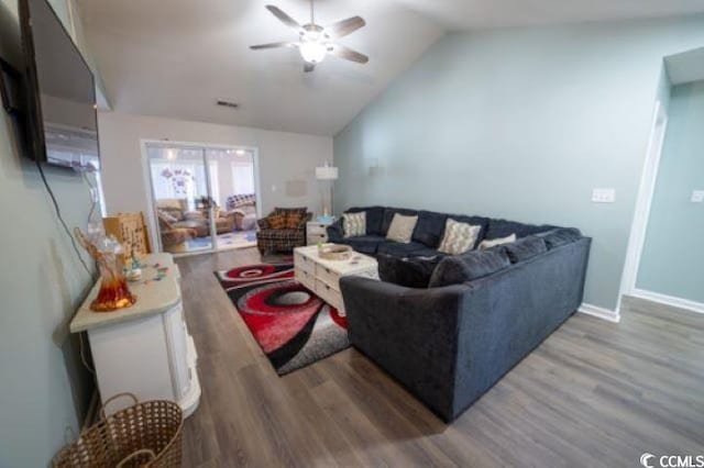 living room with hardwood / wood-style flooring, ceiling fan, and vaulted ceiling