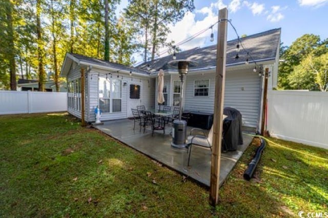 back of property with a lawn and a patio