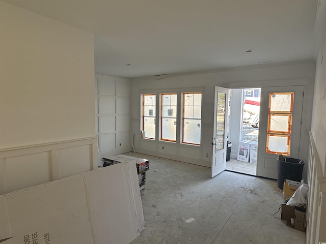 interior space featuring wainscoting and a decorative wall