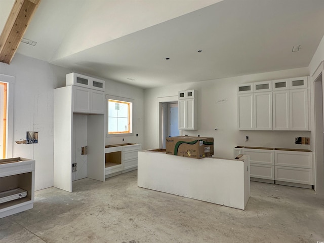 kitchen with lofted ceiling, glass insert cabinets, and white cabinets