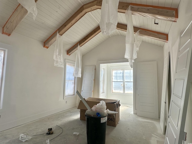 interior space with plenty of natural light, lofted ceiling with beams, and baseboards