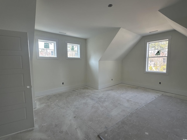 additional living space with lofted ceiling, baseboards, and a wealth of natural light