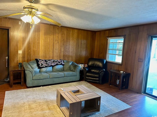 living room featuring a wealth of natural light, dark wood-type flooring, and ceiling fan