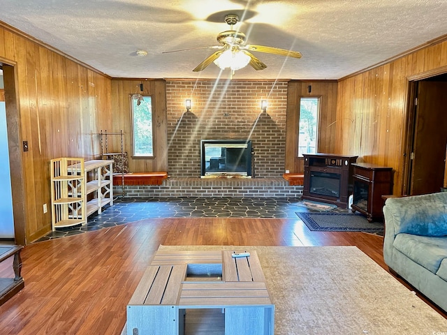 living room with plenty of natural light, dark hardwood / wood-style flooring, and a brick fireplace