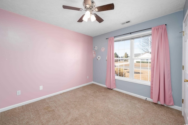 carpeted spare room with ceiling fan and a textured ceiling