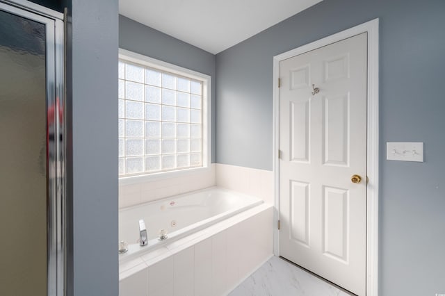 bathroom with a relaxing tiled tub