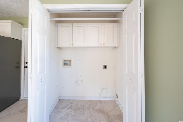 washroom with hookup for an electric dryer, cabinets, a textured ceiling, and washer hookup