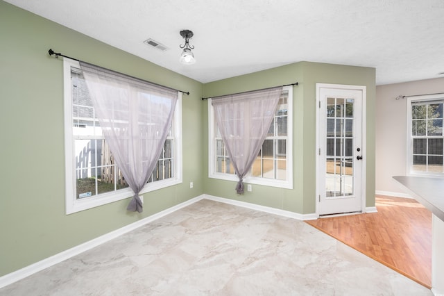 interior space featuring a healthy amount of sunlight and a textured ceiling