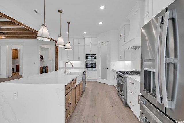 kitchen featuring pendant lighting, white cabinets, a spacious island, sink, and stainless steel appliances