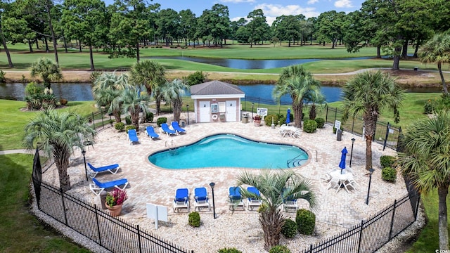 view of pool featuring a water view, a lawn, and a patio