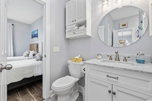 bathroom featuring wood-type flooring, toilet, and vanity