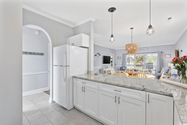 kitchen featuring white cabinets, light stone counters, and white fridge